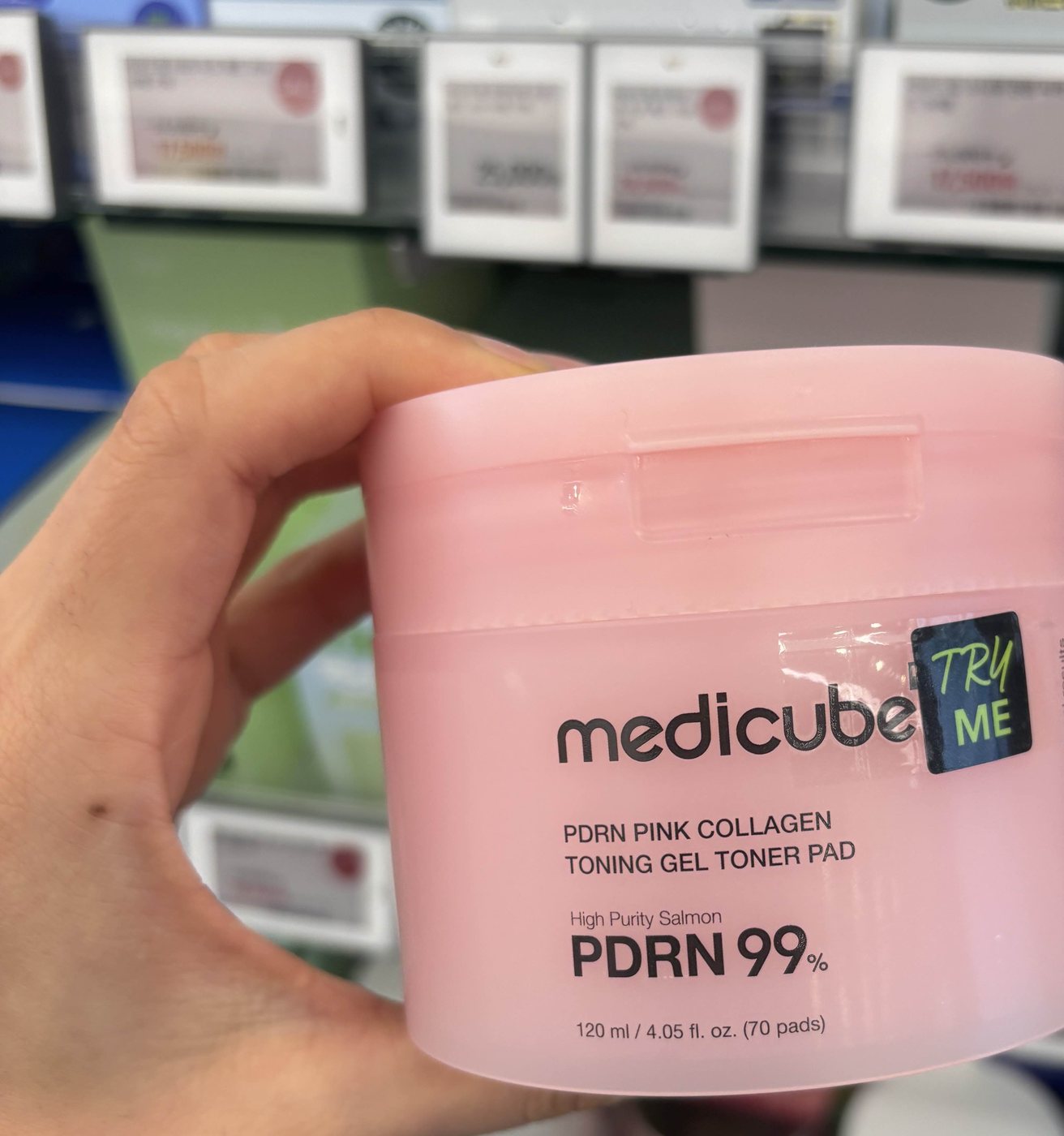 Close-up of a Medicube PDRN toner pad jar in a store aisle, printed with "High Purity Salmon PDRN 99%" above "120 ml / 4.05 fl. oz. (70 pads)"
