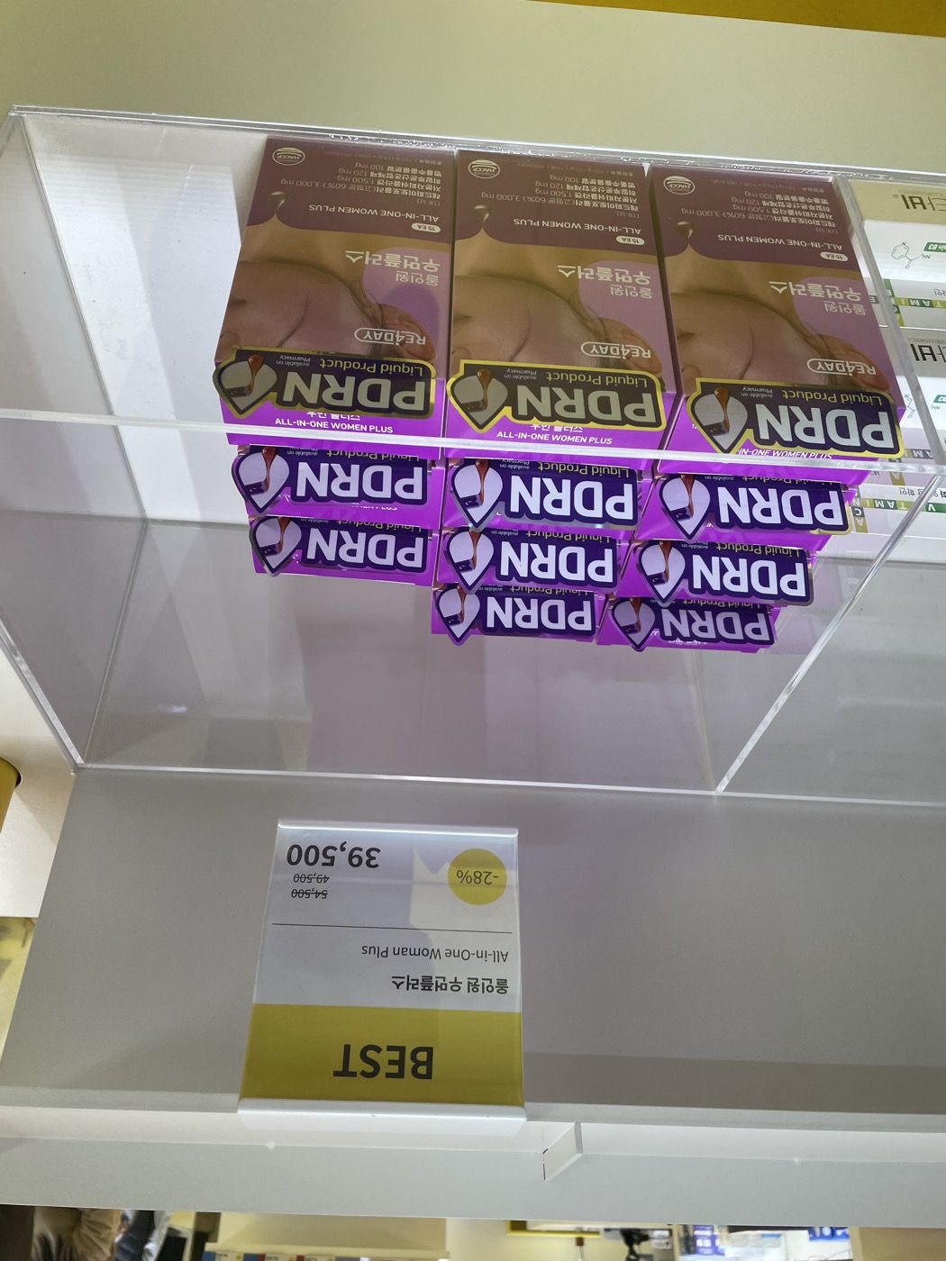 RE4DAY All-in-One Women Plus drinkable PDRN sachets in purple boxes on a Korean pharmacy shelf under a BEST sign, labeled liquid PDRN product
